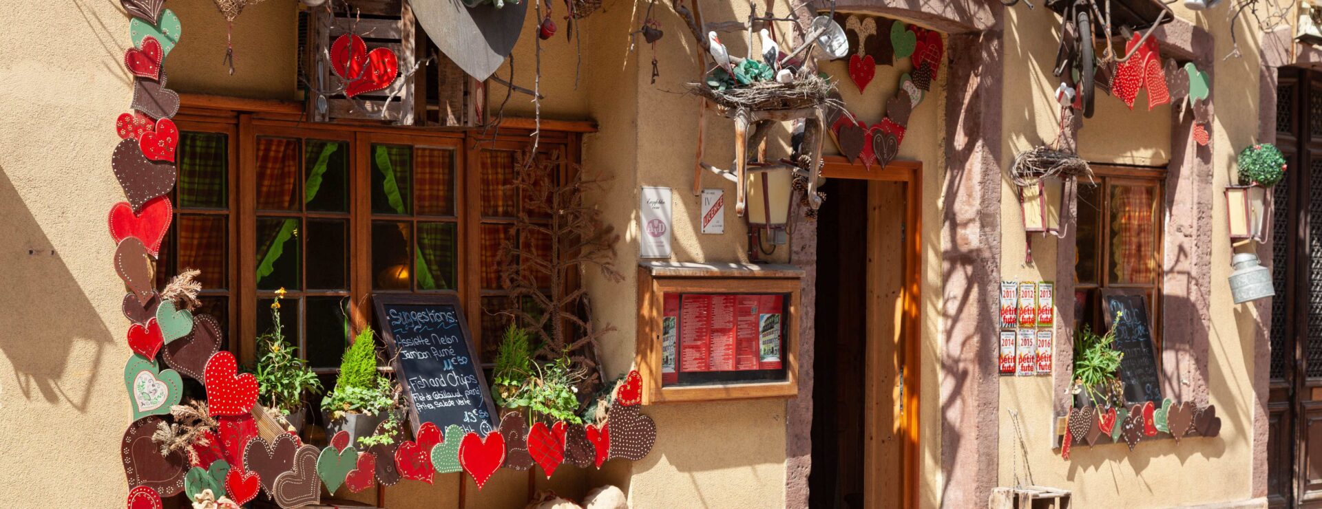 Vakwerkhuis in Colmar versierd met rode en groene kersthartjes tijdens de kerstmarkt