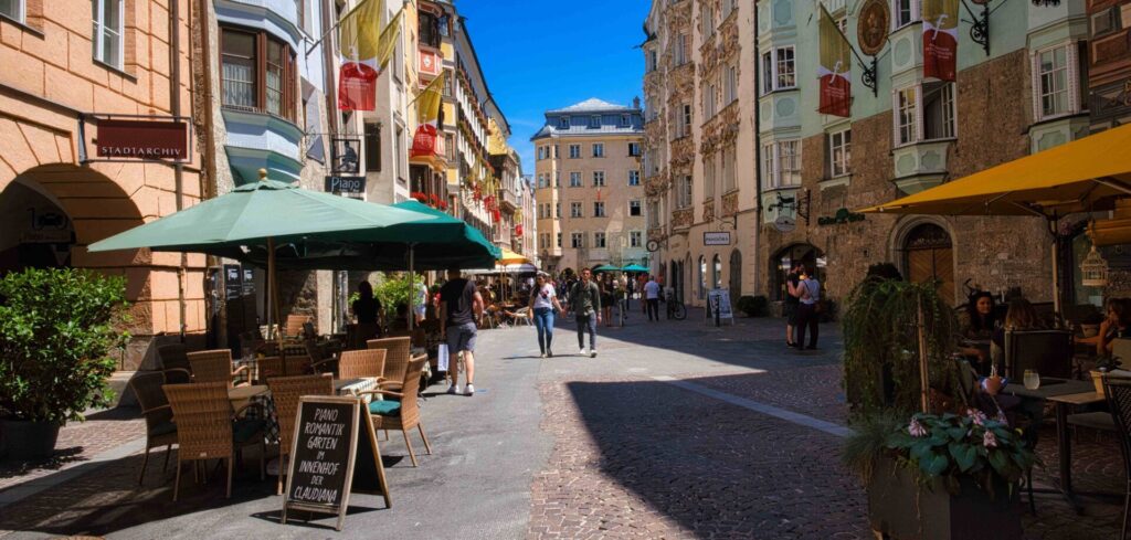 Wandelaars in een straat in de oude binnenstad van Innsbruck, met historische gevels aan weerszijden