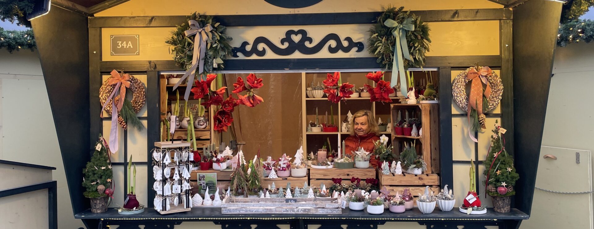 Verkoper achter een verlichte houten kraam op de kerstmarkt in München